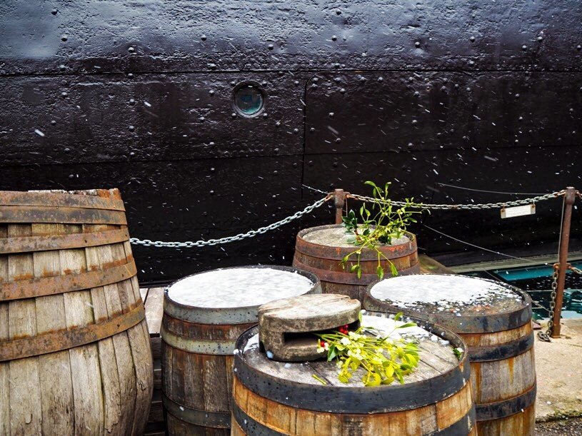 Snowy barrels and holly outside the ship