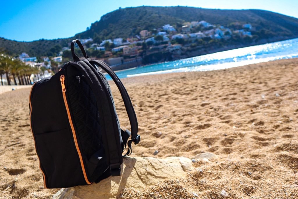 The Travel Hack carry-on backpack for women on El portet beach