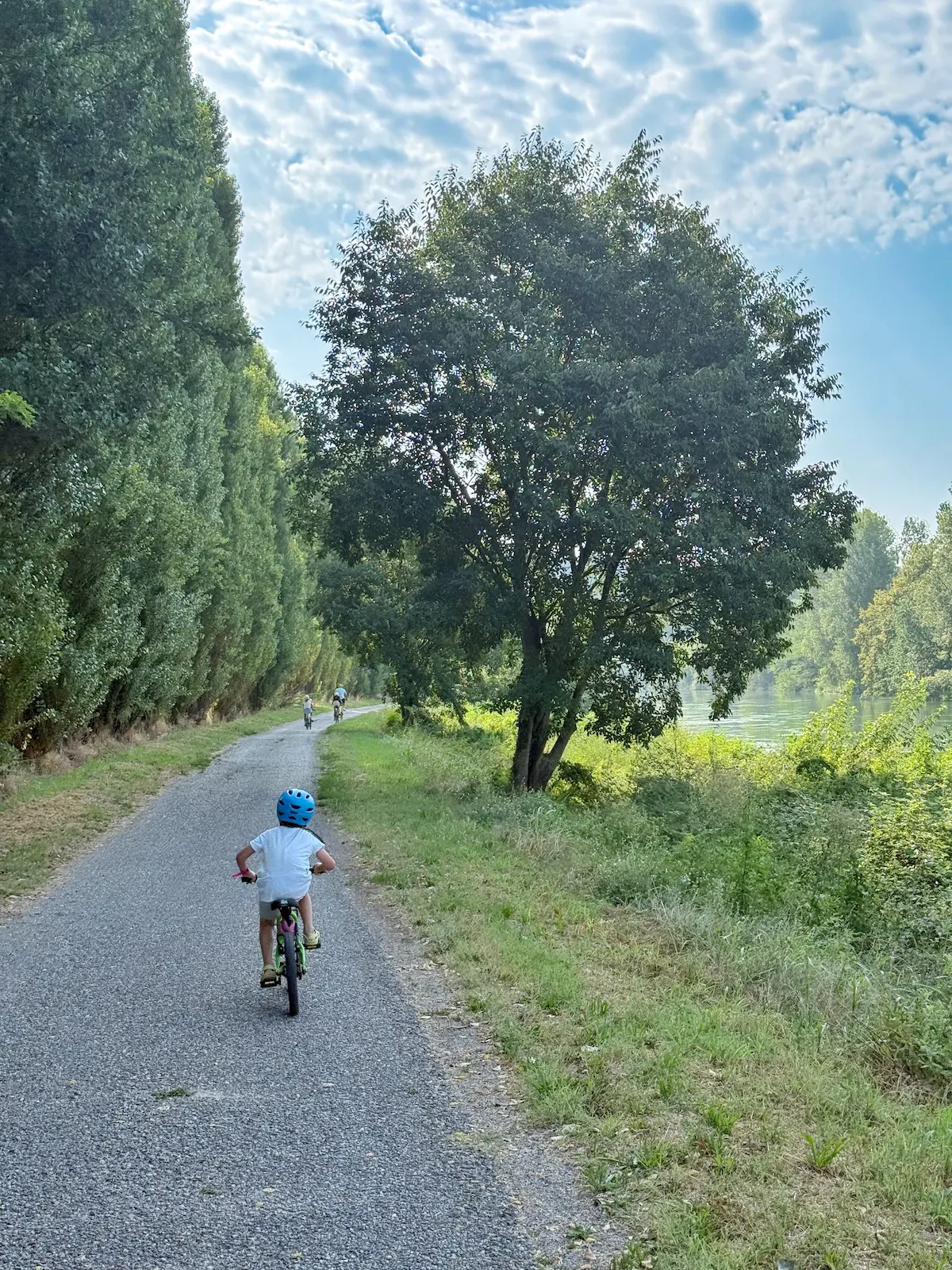 Family cycling the Mantua-Peschiera cycle path from Hu Altomincio Village